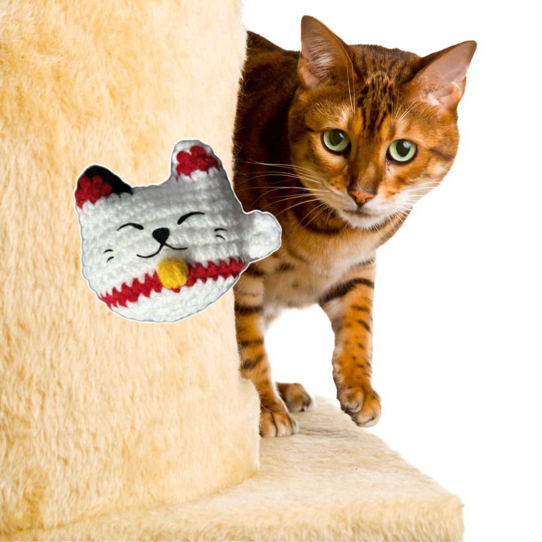 Cat playing with a lucky cat-shaped Chunkle Chunk plush cat toy on a beige cat tree.
