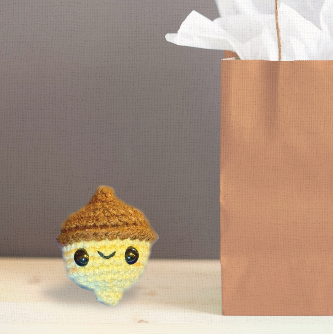 Augie the Acorn, a handmade Chunkle Puff catnip toy by Feline Grove, shown with his boutique gift bag. The woven acorn toy is presented as a luxury piece designed for gifting and refined play.