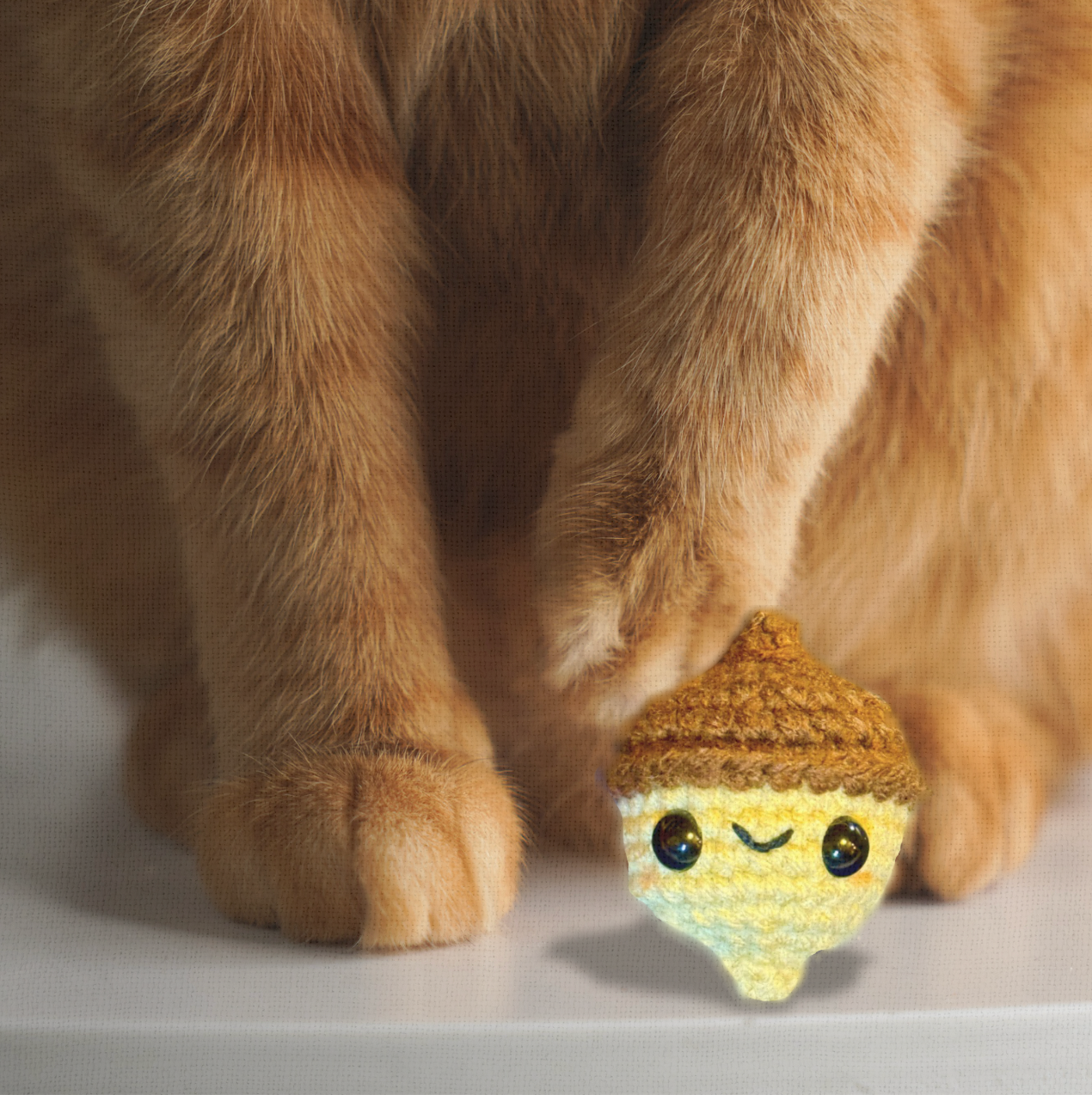 Augie the Acorn, a handmade Chunkle Puff catnip toy measuring approx. 2 inches, shown beside a familiar object for scale. His acorn form highlights small, tossable size and boutique craftsmanship.