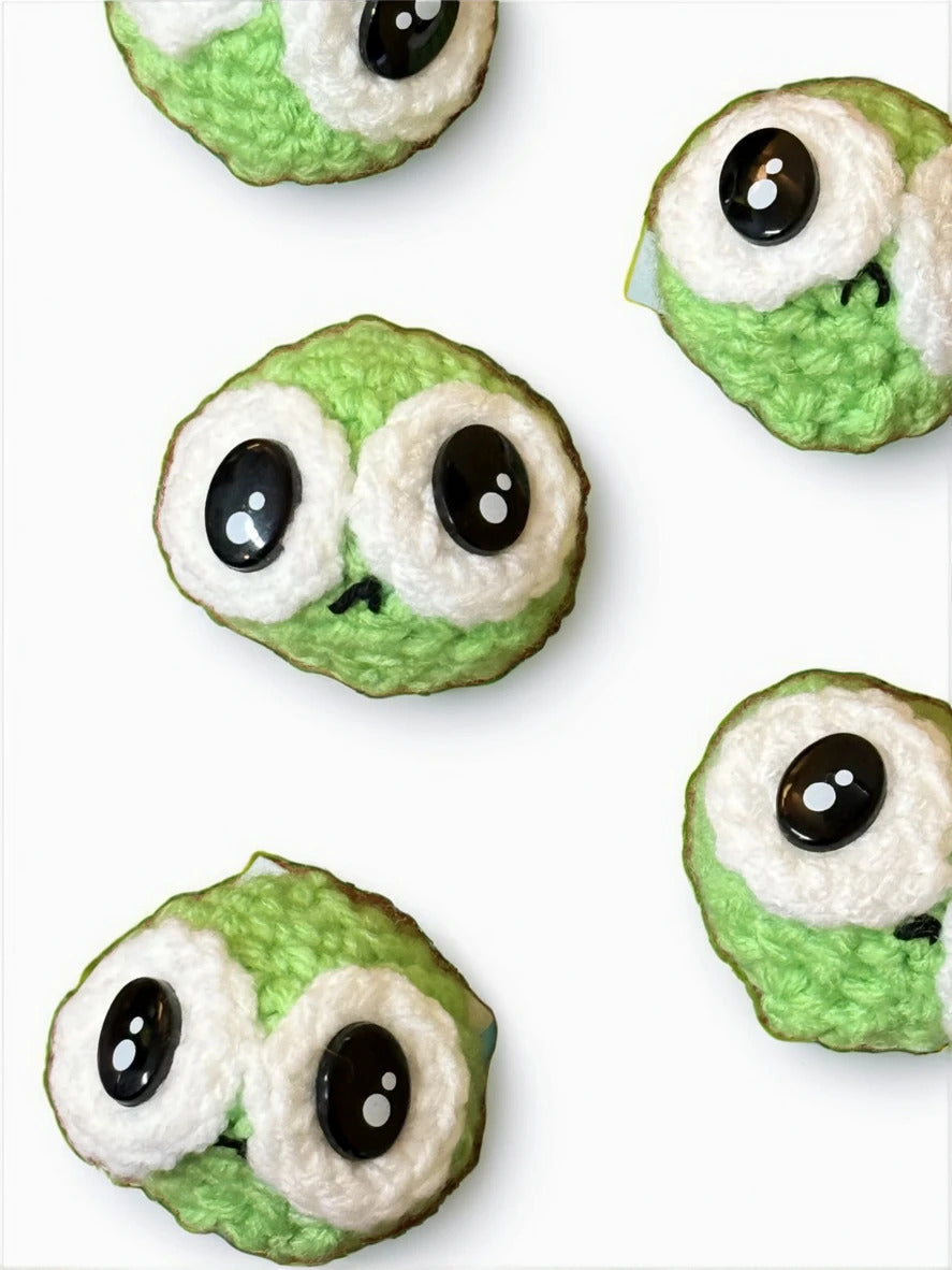 Green grumpy pea cat toys with black eyes on a white background