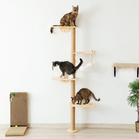 Three cats explore the Feline Hollow Vertical Nesting Tree, a tall, wall-mounted pine structure with four smooth wood platforms, a white fabric hammock, and a sisal-wrapped post for climbing and scratching.