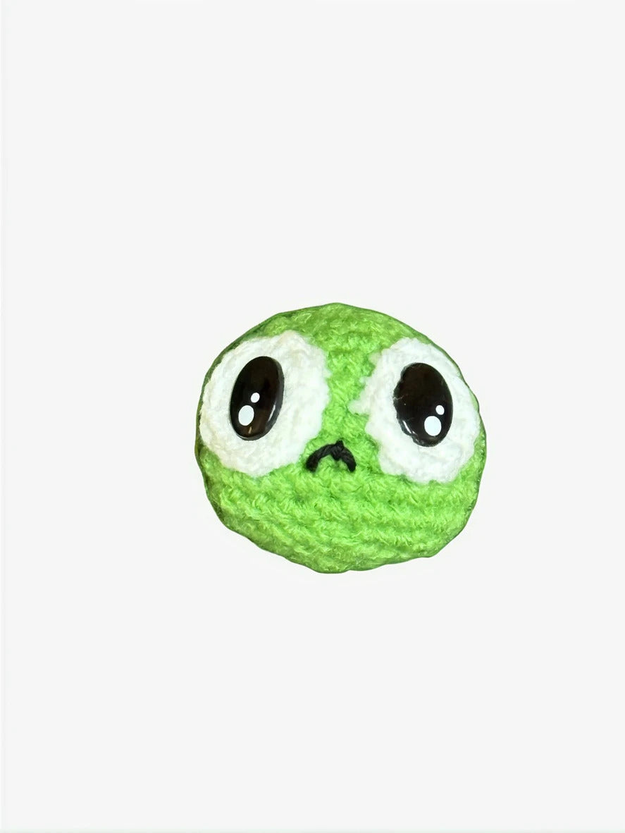Green plush pea shaped Chunkle toy with googly eyes on a white background