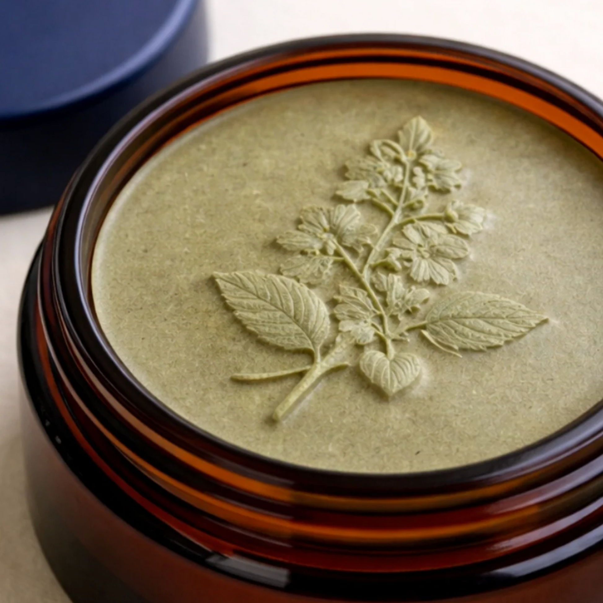 Feline Grove's calm balm in jar with leaf design in it's amber glass jar container